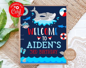 Puede incluir: Un letrero de cumpleaños azul marino con un tema de tiburones. El letrero dice "Welcome to Aiden's 3rd Birthday" en texto rojo y azul. Presenta tiburones de dibujos animados, una pelota de playa y un salvavidas. El letrero es una plantilla editable.