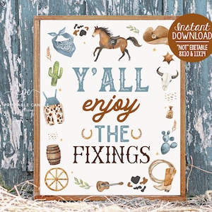 May include: A printable sign with a rustic wooden frame and a white background. The sign says "Y'all enjoy the fixings" in brown and blue lettering. The sign is decorated with various western-themed illustrations, including a cactus, a cowboy hat, a horseshoe, a barrel, a wagon wheel, a guitar, and a pair of cowboy boots.