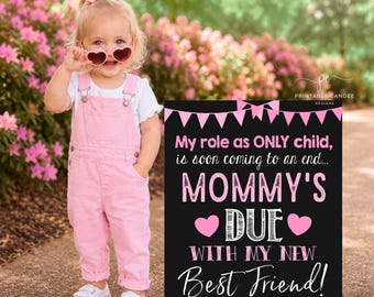 Op de afbeelding: Een jong kind in een roze overall en een hartvormige zonnebril staat naast een zwart bord. Op het bord staat: "Mijn rol als ENIGE kind, komt ten einde... MOMMY'S DUE WITH MY NEW Best Friend! ARRIVING: AUGUST 2027."