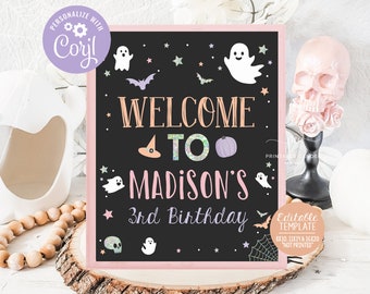 Puede incluir: Un letrero negro de pizarra con un borde rosa, decorado con fantasmas, estrellas y murciélagos. El texto dice "Bienvenido a Madison's 3rd Birthday". El letrero está sobre una superficie de madera con una decoración de calavera.
