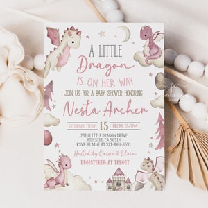 Op de afbeelding: Een roze en witte babyshower-uitnodiging met een aquarel-illustratie van een roze draak. De uitnodiging luidt "A Little Dragon is on her way" en bevat de naam "Nesta Archer".