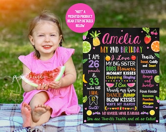 May include: A chalkboard sign with a tropical fruit theme for a 2nd birthday. The sign says "Amelia My 2nd Birthday" and includes details about the child, such as their weight, height, and favorite things. The sign is decorated with colorful fruit illustrations.
