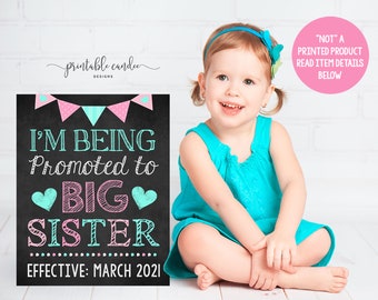 May include: A printable sign announcing a promotion to big sister. The sign is on a black chalkboard background with pink and blue bunting and hearts. The text reads "I'm being promoted to big sister. Effective: March 2021".