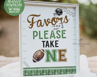 May include: A white sign with a green and brown football theme. The sign says "Favors Please Take One" with a football graphic. The sign is framed in a white frame and has a green and white football field design at the bottom.