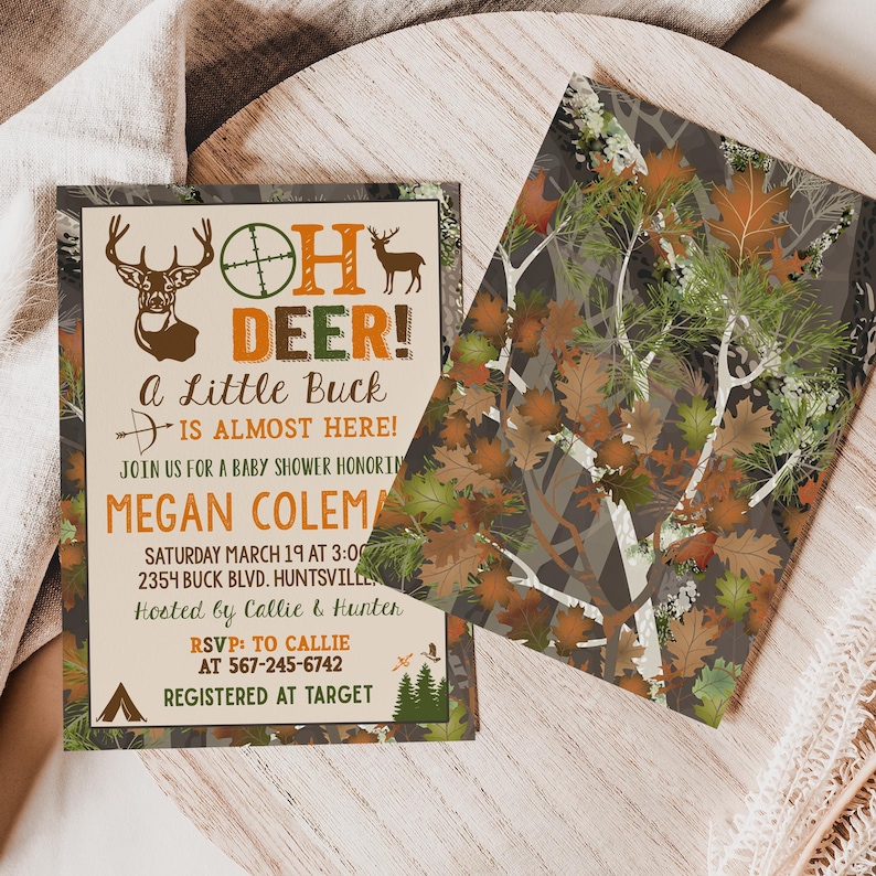 May include: A baby shower invitation with a camouflage background. The text reads "Oh Deer! A Little Buck is Almost Here!" with a deer silhouette and a target symbol. The invitation includes the name "Megan Coleman", the date and time of the shower, the address, and the RSVP information.