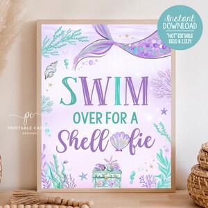 Puede incluir: Un cartel imprimible de temática de sirena en morado y turquesa con el texto "Swim Over For A Shell-fie". El cartel presenta una cola de sirena, conchas marinas y un cofre del tesoro.