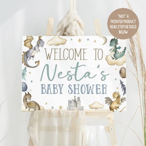 May include: A white baby shower sign with a blue and gold dragon design. The sign says "Welcome to Nesta's Baby Shower".