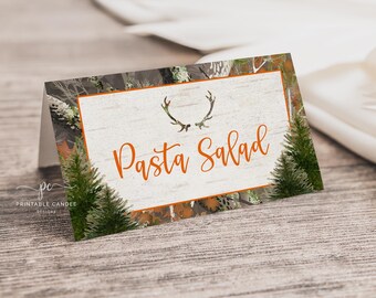 May include: A printable food label with a camouflage pattern, orange antlers, and the text "Pasta Salad".