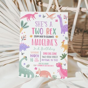 Może przedstawiać: R&oacute;żowe i zielone zaproszenie na przyjęcie urodzinowe z dinozaurami z tekstem "She's a Two Rex" i "Madeline's 2nd Birthday". Zaproszenie zawiera lokalizację, datę i godzinę strefy wykopalisk dinozaur&oacute;w.