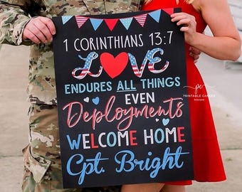 May include: A black chalkboard sign with white, red, and blue lettering. The sign reads "1 Corinthians 13:7 Love Endures All Things Even Deployments Welcome Home Cpt. Bright".