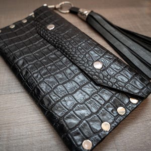 Cartera grande de cuero negro con detalles de remaches plateados y llavero desmontable con flecos – Cuero con estampado de serpiente Dilema minimalista, punk e irónico