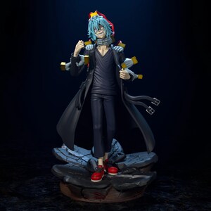 May include: A detailed figurine of a character with blue hair, wearing a black coat, pants, and a dark shirt. The figure has multiple hands and is standing on a rocky base. Red sneakers complete the look.