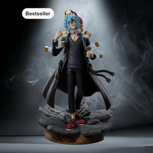 May include: A detailed figurine of a character with blue hair, a black coat, and red shoes. The figure has multiple gold-colored attachments and stands on a rocky base. The word "Bestseller" is in a white oval in the upper left corner.