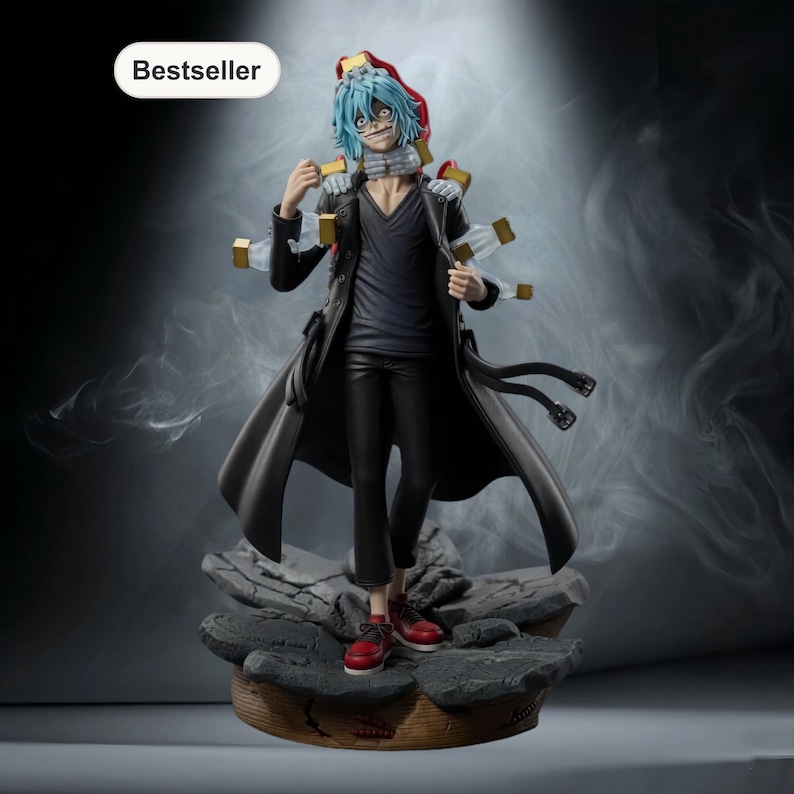 May include: A detailed figurine of a character with blue hair, a black coat, and red shoes. The figure has multiple gold-colored attachments and stands on a rocky base. The word "Bestseller" is in a white oval in the upper left corner.