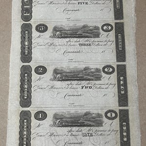 Könnte beinhalten: Eine Sammlung antiker Banknoten mit Werten von eins, zwei, drei und fünf Dollar. Jede Note zeigt aufwendige Designs, darunter eine Landschaftsszene und kunstvollen Text. Die Noten sind in schwarzer Tinte auf gealtertem Papier gedruckt.