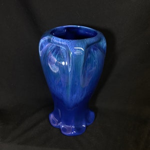 May include: A blue ceramic vase with a flared base and a textured, swirled glaze.
