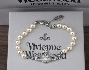 Bracciale VW con perle, ciondolo Saturno in argento con zirconi, regalo incluso.