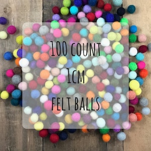May include: A large assortment of 100 colorful felt balls, each measuring 1 inch in diameter. The balls are arranged in a random pattern and are a mix of bright and pastel colors.