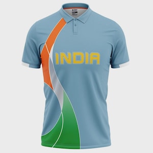 May include: Pale blue polo shirt with the word "INDIA" in yellow. The shirt has a curved design in orange, white, and green, reminiscent of a flag. White trim is on the sleeves.