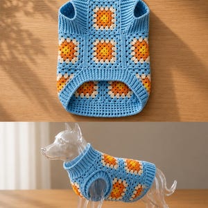 May include: A light blue crochet dog sweater with a turtleneck collar and armholes. The sweater features a granny square design with orange and cream-colored flower motifs. The sweater is shown on a clear plastic dog figurine.