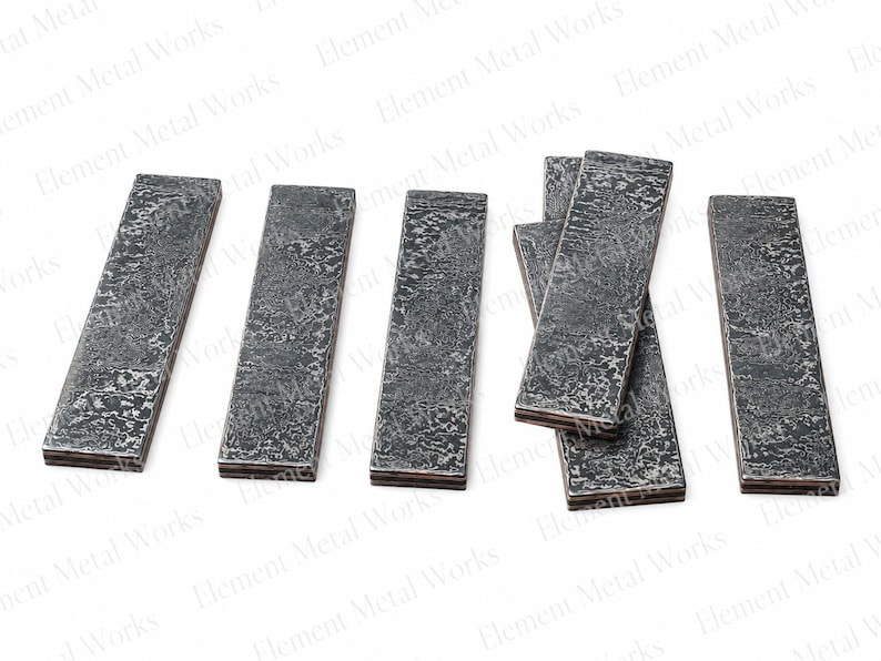 May include: Six rectangular metal bars with a dark, textured, hammered finish. The bars are arranged in a row, with one group of three overlapping slightly. Each piece has a distinct, rugged surface pattern and a layered appearance on the edges.