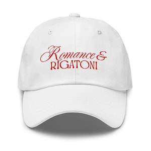 Może przedstawiać: Biała czapka bejsbolowa z czerwonym haftem "Romance & Rigatoni". Czapka ma zakrzywiony daszek i klasyczny sześciopanelowy design. Codzienny dodatek do noszenia na co dzień.