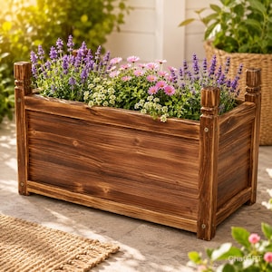 May include: A rectangular wooden planter box filled with vibrant flowers. The box is stained a warm brown and features decorative posts at each corner. The flowers include lavender, pink daisies, and white blossoms, creating a colorful display.