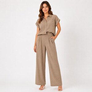 May include: A taupe two-piece set consisting of a short-sleeved button-down shirt with a collar and a chest pocket, paired with matching high-waisted wide-leg trousers featuring side pockets and a pleated front design in a solid neutral color.