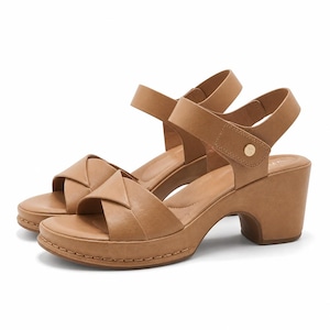 May include: A pair of tan sandals featuring a thick block heel, a platform sole with visible stitching, and crisscross straps over the toe. The sandals include an adjustable ankle strap secured with a small gold-toned circular metal stud detail.