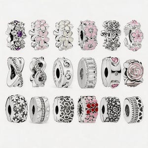 May include: A collection of silver-toned charm beads with various designs. Some charms feature floral patterns with pink and white enamel, while others have clear crystals, geometric shapes, and heart accents. The beads are designed for bracelets.
