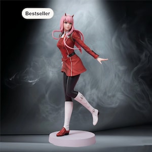 Könnte beinhalten: Figur einer Figur mit rosa Haaren und Hörnern, die ein rotes Outfit, schwarze Leggings und weiße Stiefel trägt. Die Figur steht auf einem hellrosa Sockel, mit "Bestseller" in einem weißen Oval oben links.