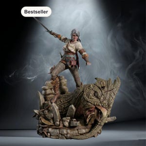 Può includere: Statuetta dettagliata di una donna con i capelli argentati, che tiene una spada, in piedi su una struttura in pietra con una testa di drago. La figura indossa una camicia chiara, pantaloni marroni e stivali. La parola "Bestseller" è in un ovale bianco.