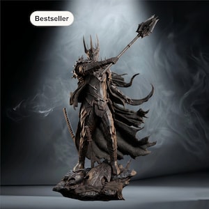 May include: A detailed statue of a dark armored figure holding a spear, with a sword at its side. The figure is standing on a rocky base. The statue is dark brown with a black cape. The word "Bestseller" is in a white oval in the upper left corner.