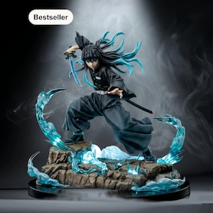 Op de afbeelding: Gedetailleerd beeldje van een personage in een dynamische pose, met een zwaard. Het figuur is gekleed in een donkere outfit met lang zwart haar en turquoise accenten. De basis heeft een rotsachtig terrein met gloeiende blauwe energie-effecten.