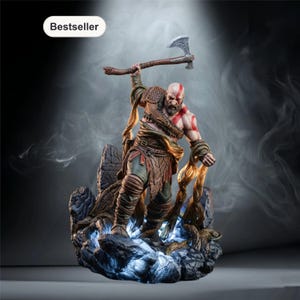 May include: A detailed figurine of a muscular warrior with a red face marking, holding an axe. The figure is posed on a rocky base with glowing blue accents. The word "Bestseller" is in a white oval in the upper left corner.