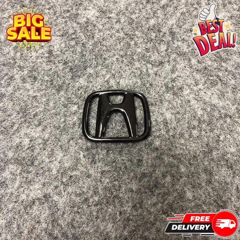 May include: A glossy black Honda emblem, featuring the iconic 'H' logo within a rectangular frame. The emblem is centered on a gray textured surface. The image also includes text that says "BIG SALE" and "BEST DEAL!"
