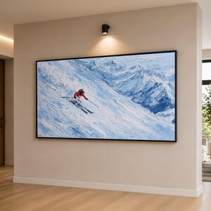以下が含まれることがあります： 赤いジャケットを着たスキーヤーが雪山を滑降する様子を描いた、大きな額入りの絵画。このアートワークは、青と白の色合いで、テクスチャのある印象派スタイルを特徴としています。黒いフレームがアートワークを引き立てています。