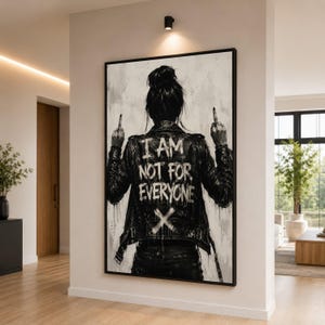 May include: Black and white framed artwork featuring a figure in a leather jacket with the text "I AM NOT FOR EVERYONE." The figure is facing away, with both hands raised, displaying the middle finger. The artwork is displayed in a modern interior.