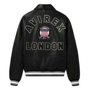 May include: Black leather jacket with white embroidered lettering that reads "AVIREX LONDON" on the back. A circular patch with an American flag design is centered between the words. The jacket has a ribbed collar, cuffs, and hem with white stripes.