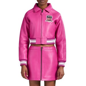 K&ouml;nnte beinhalten: Ein leuchtend pinkfarbenes Lederjacken- und Minirock-Set. Die Jacke hat einen Rei&szlig;verschluss, einen Kragen und einen Aufn&auml;her auf der Brust. Die Manschetten und der Saum der Jacke haben wei&szlig;-rosa Streifen. Der Rock hat einen Frontrei&szlig;verschluss.