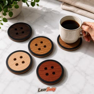 May include: A set of four circular wooden coasters designed to look like large buttons, each featuring four holes in the center and a black outer rim. The coasters are made from different wood tones, including light, medium, and dark brown shades.