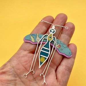 TRAVEL BUG Anhänger Insektenschmuck Fundstück Anhänger. Ein großer Käfer mit gelb und blau lithografierter Landkarte aus Blech