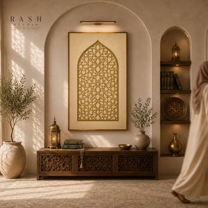 Peut inclure: Intérieur avec une grande œuvre d'art encadrée avec un motif doré complexe, un meuble en bois et une lanterne décorative. La pièce a des portes arquées et une palette de couleurs neutres, avec une femme marchant en arrière-plan. Le texte "RASH STUDIO" est visible.