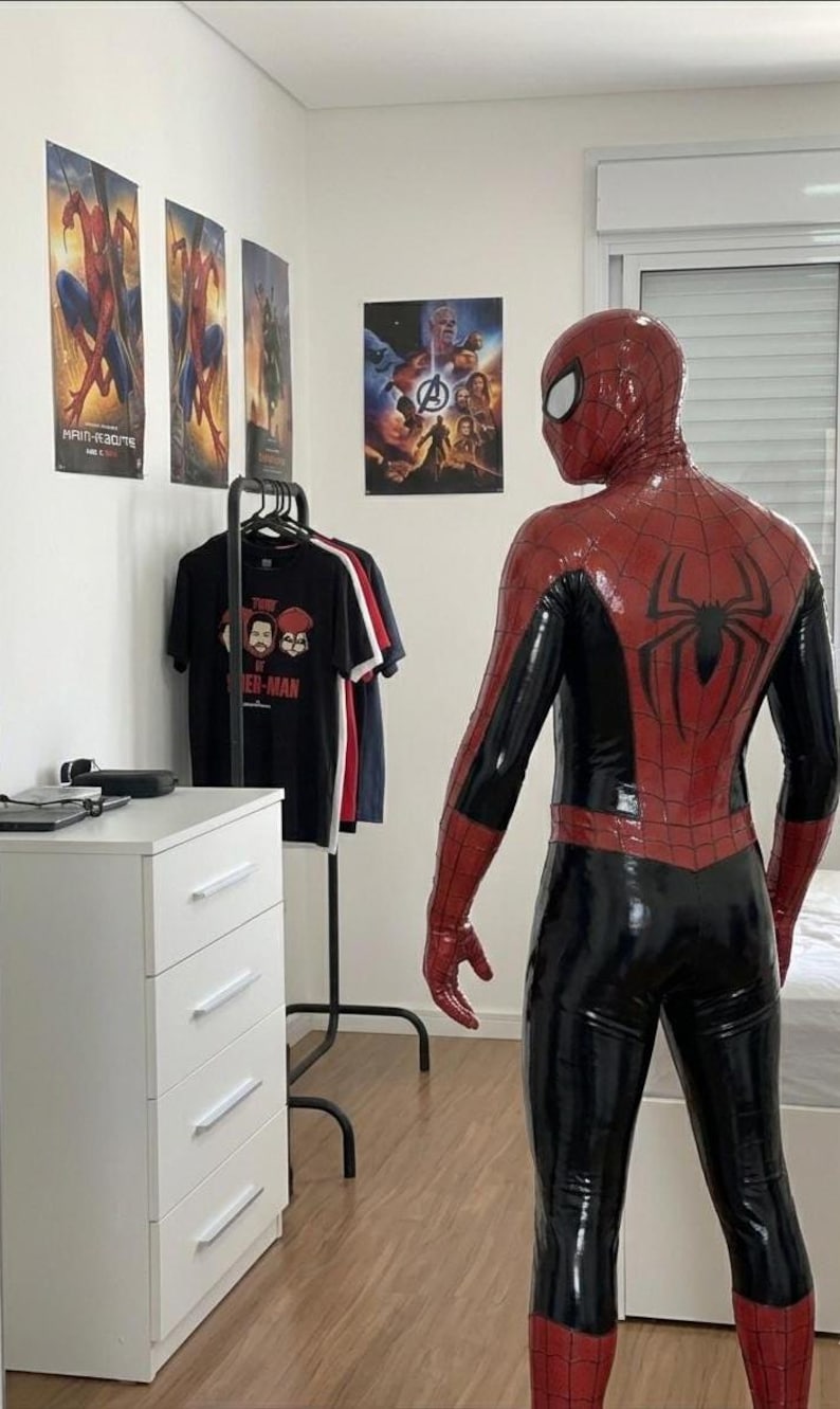 Puede incluir: Un disfraz de Spider-Man de cuerpo completo hecho de un material brillante rojo y negro. El traje presenta un prominente emblema de ara&ntilde;a negra en la espalda, un patr&oacute;n de telara&ntilde;a texturizado en las secciones rojas y una m&aacute;scara a juego.
