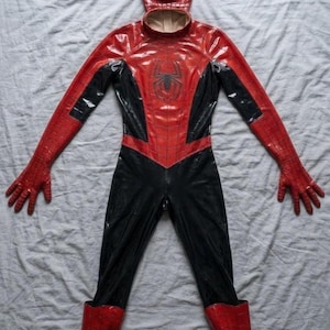 Puede incluir: Un disfraz de superh&eacute;roe de cuerpo completo en rojo y negro con acabado brillante, un emblema de ara&ntilde;a en el pecho, guantes integrados y botas a juego. Incluye una m&aacute;scara con grandes lentes oculares blancos y un dise&ntilde;o de patr&oacute;n de telara&ntilde;a.