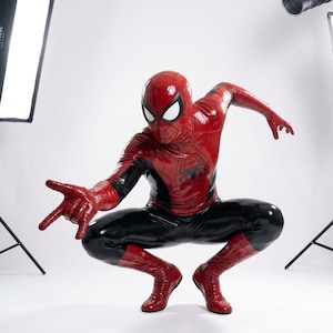 Puede incluir: Un disfraz de superh&eacute;roe de cuerpo completo en rojo y negro con un acabado brillante similar al l&aacute;tex. El traje incluye una m&aacute;scara con grandes lentes oculares blancos, un emblema de ara&ntilde;a en el pecho y un patr&oacute;n de telara&ntilde;a en el tejido rojo.
