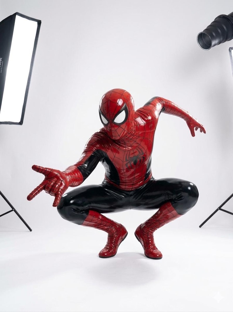 Puede incluir: Un disfraz de superh&eacute;roe de cuerpo completo en rojo y negro con un acabado brillante similar al l&aacute;tex. El traje incluye una m&aacute;scara con grandes lentes oculares blancos, un emblema de ara&ntilde;a en el pecho y un patr&oacute;n de telara&ntilde;a en el tejido rojo.