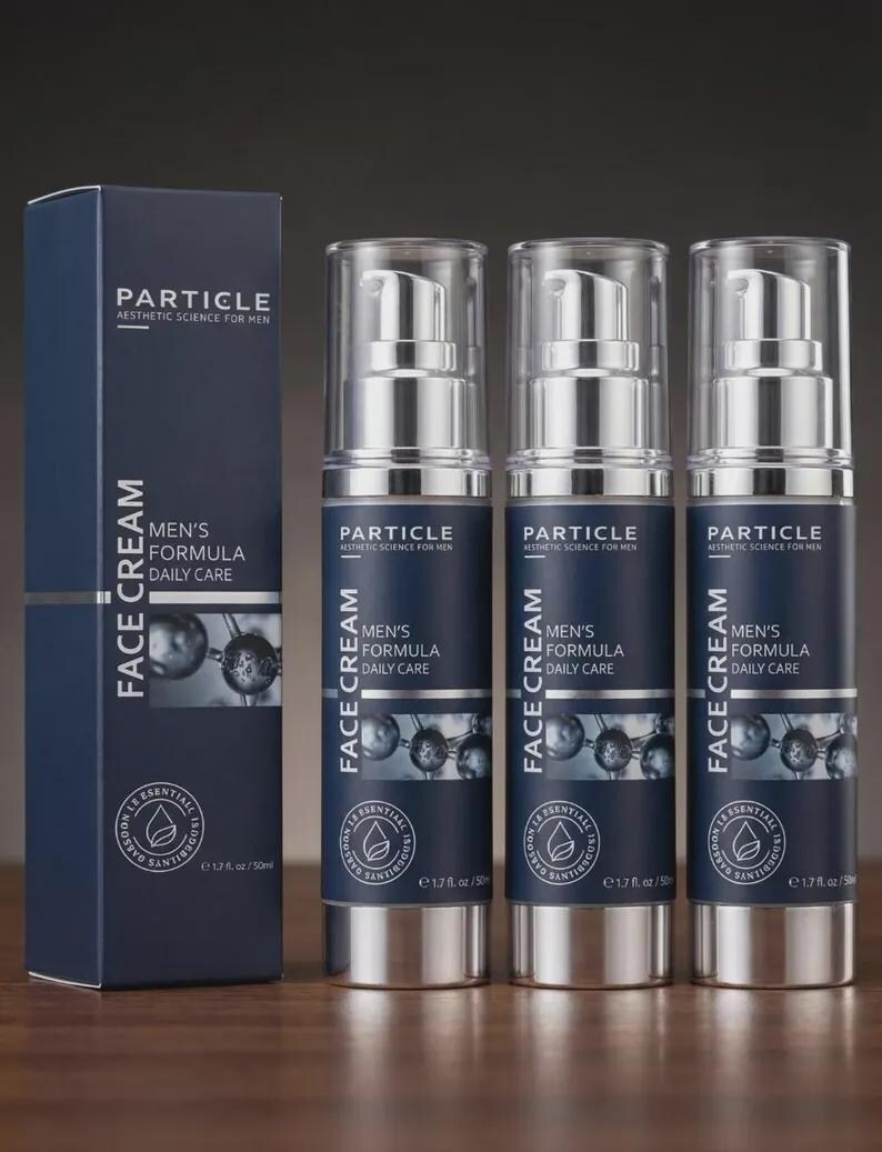 Pu&ograve; includere: Un set di prodotti per la cura della pelle con una scatola blu navy e tre flaconi con pompa argento e blu navy. La scatola e i flaconi mostrano il testo "PARTICLE Aesthetic Science for Men" e "MEN'S FORMULA DAILY CARE FACE CREAM". Ogni flacone contiene 50 ml.