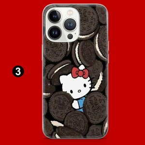 May include: A clear phone case featuring a design of Oreo cookies and a cartoon image of Hello Kitty with a red bow. The phone case has a black and white cookie pattern.