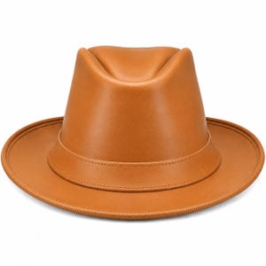 May include: A tan fedora hat with a smooth, matte finish. The hat features a structured crown with a central crease and a wide, flat brim. A matching tan band encircles the base of the crown, providing a clean, uniform look to the accessory.